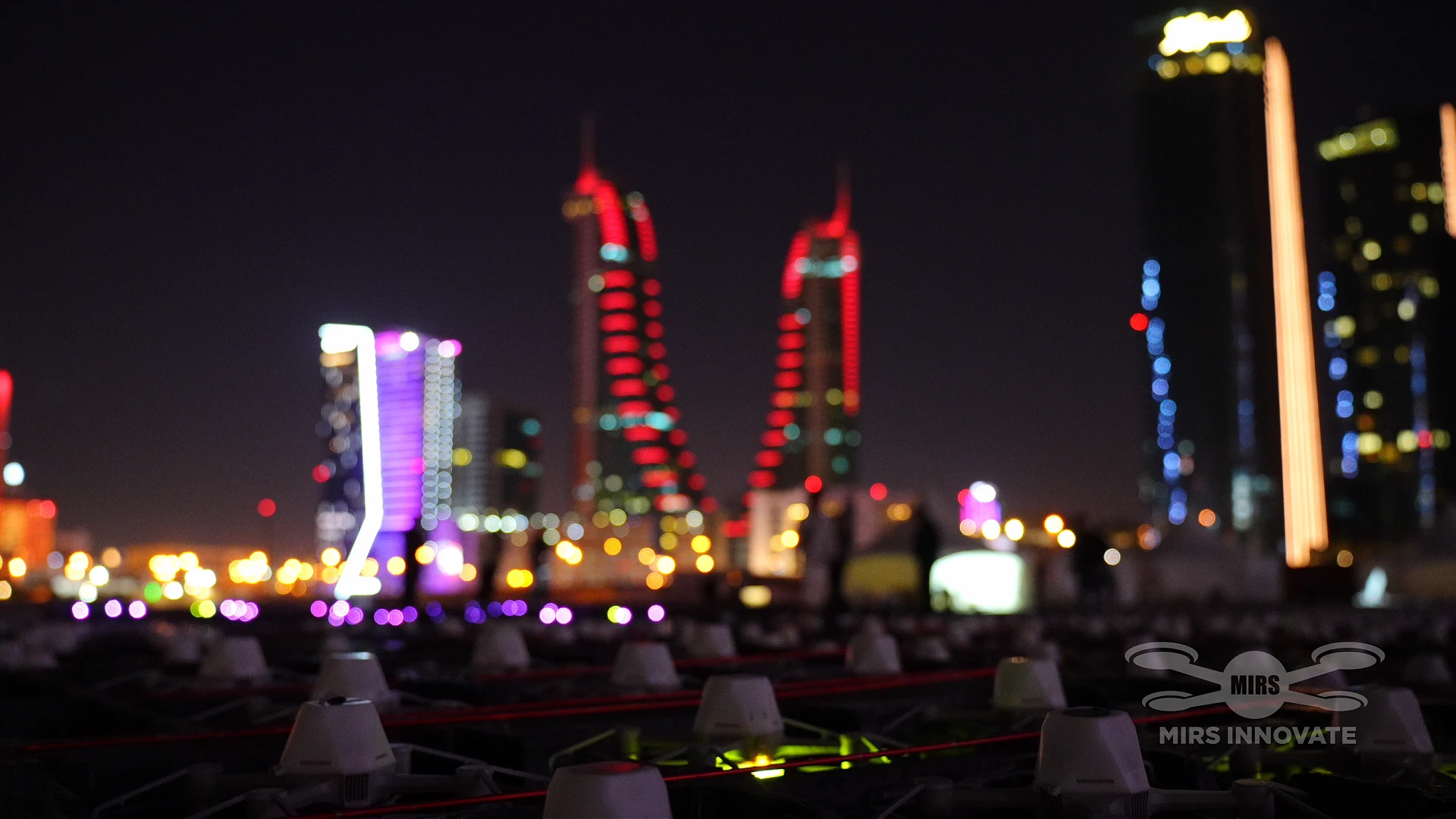 Drone fleet on the ground with Bahrain World Trade Center lit up in background at New Year 2026 drone show Manama