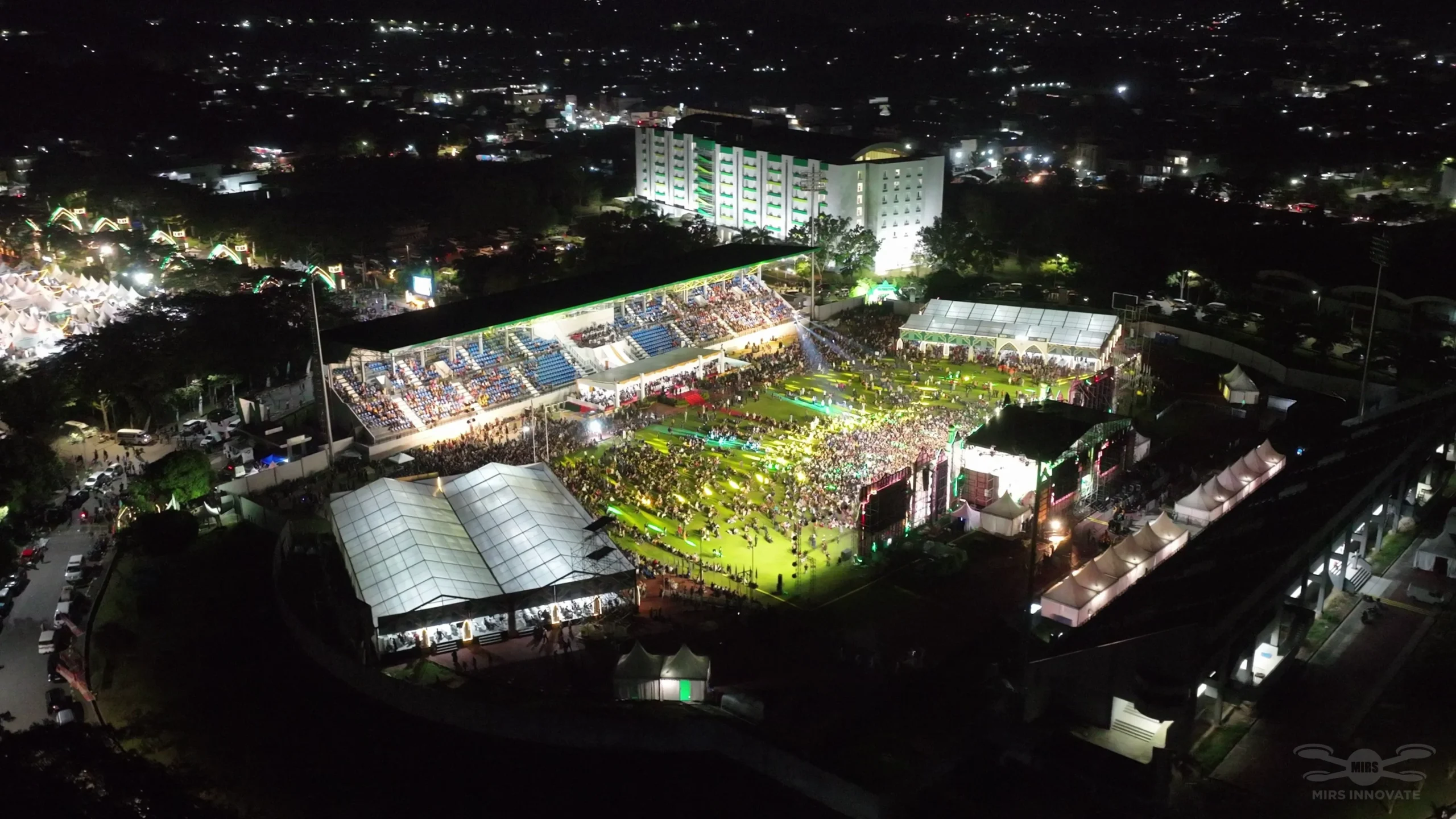Night aerial view of drone light formations above Samarinda Stadium — 500 drones in synchronized show at MTQN XXX 2024, East Kalimantan