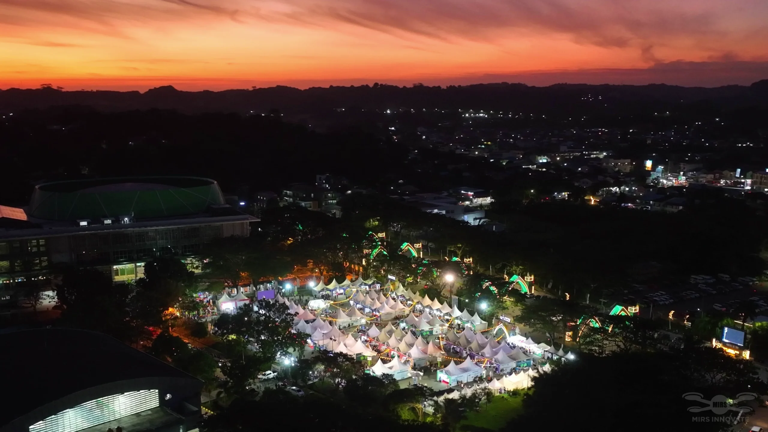 Sunset golden hour aerial view of the MTQN XXX venue at Samarinda Stadium — East Kalimantan, Indonesia, before the drone show performance