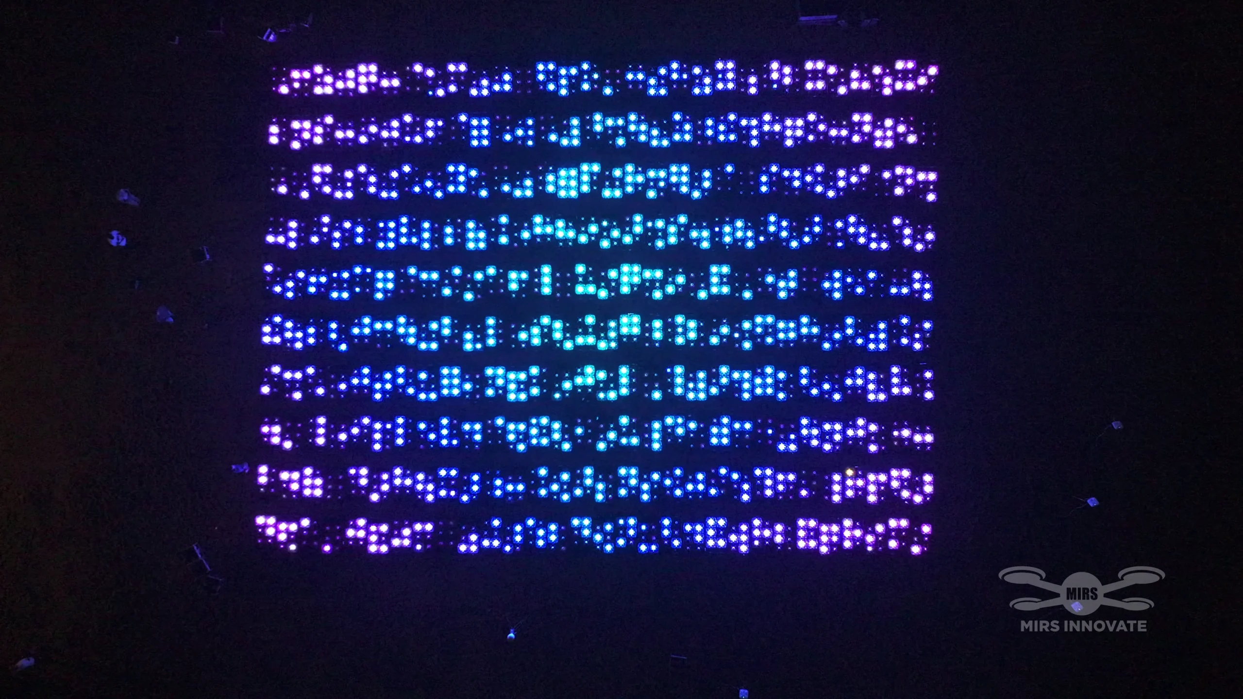 Colourful pixel-grid formation at a government celebration drone light show in Basra, Iraq — 2,000 drones