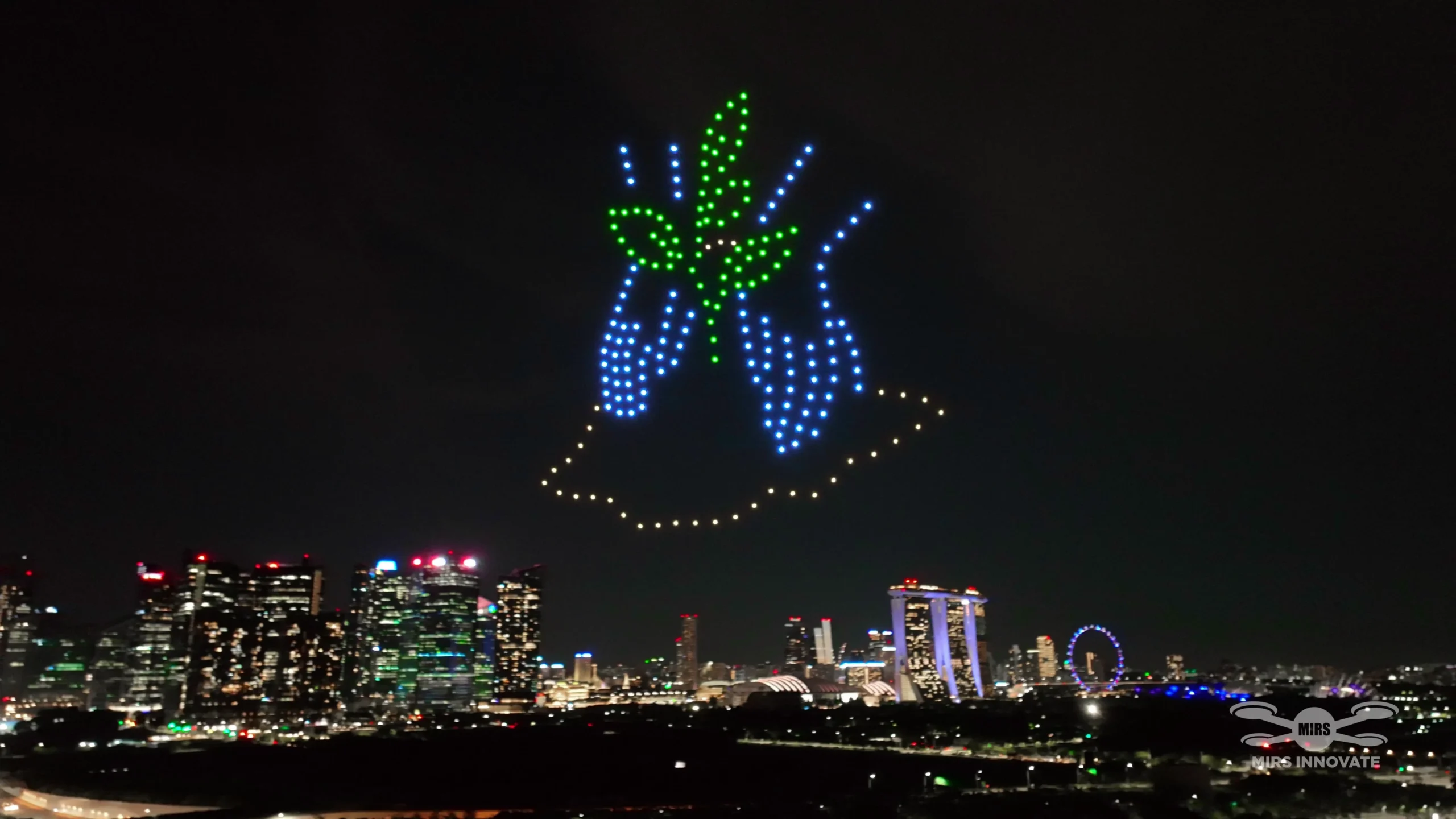 Hands holding a plant drone formation above Marina Bay for the IFA Exhibition