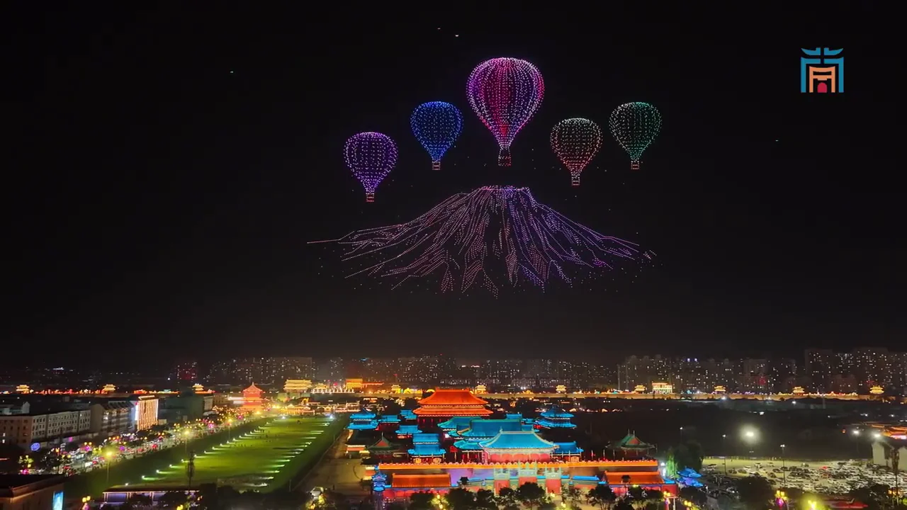 Hot-air balloons and mountain landscape formed by drones above the city