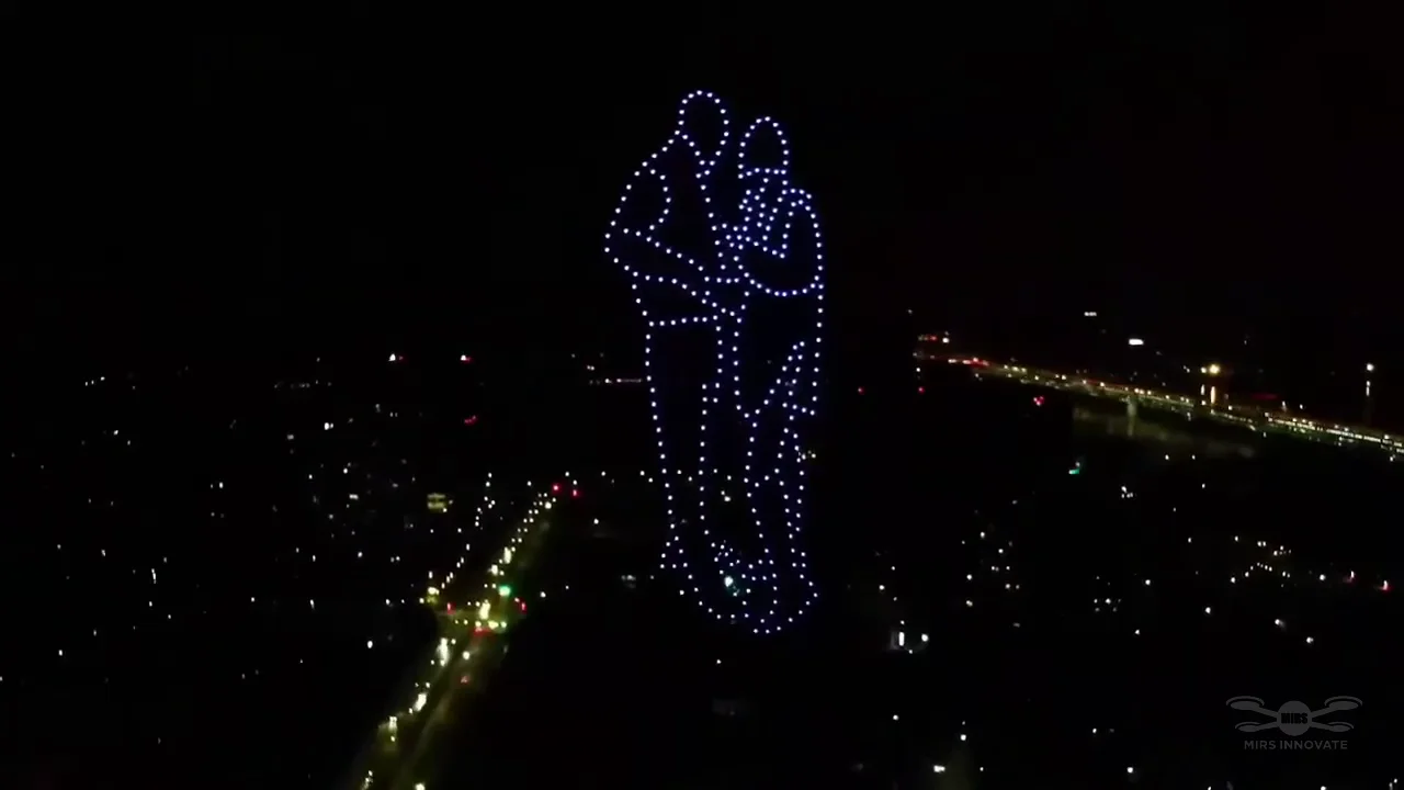 Embracing couple formed by drones above the night city