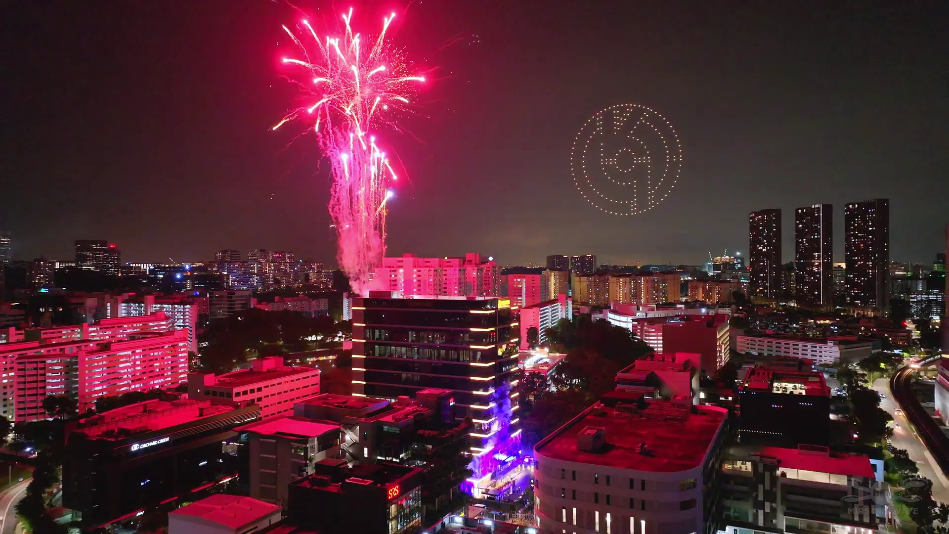 Fireworks over building skyline during Eurokars grand opening drone show in Singapore