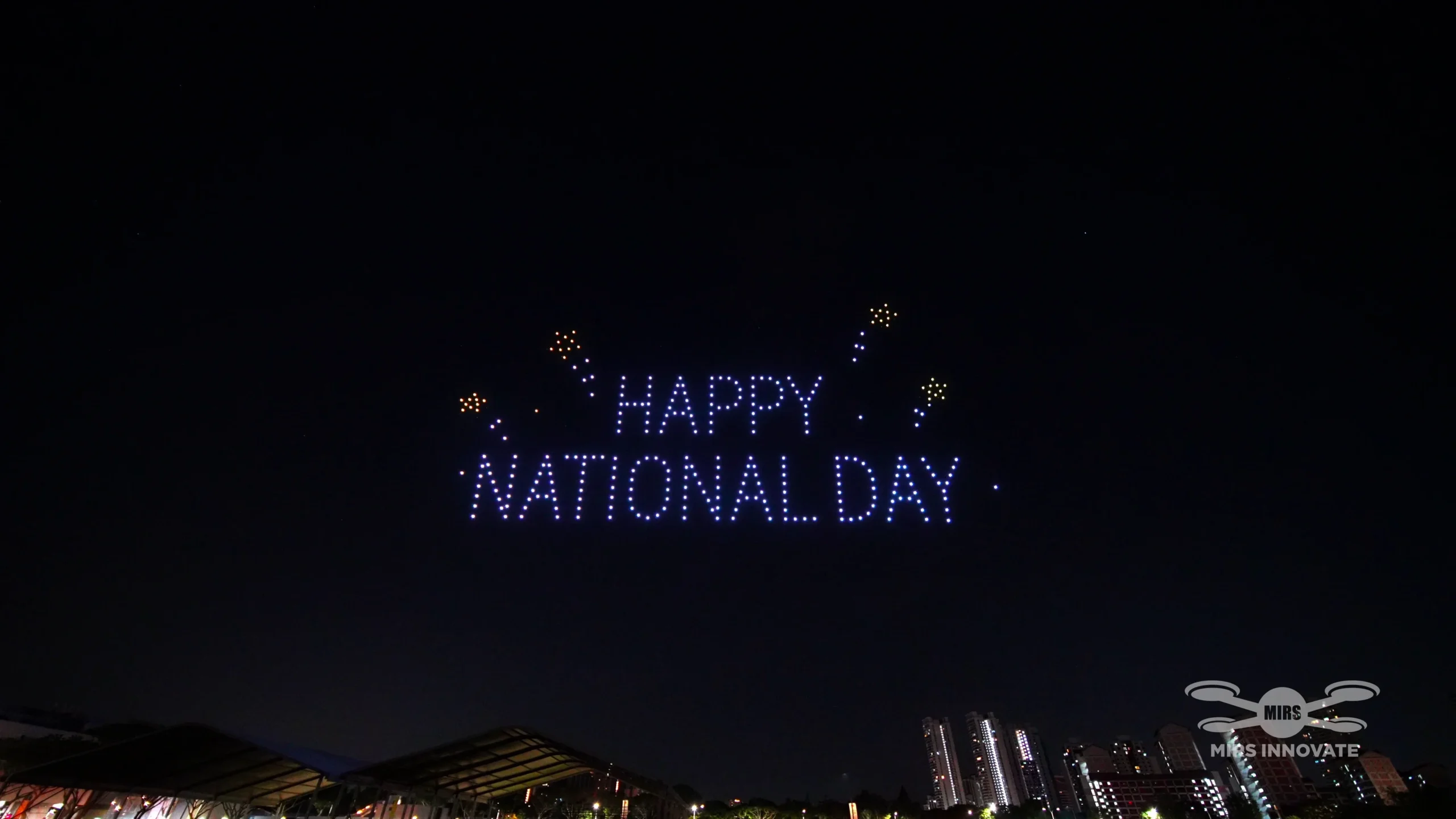 Happy National Day drone text formation against the night sky