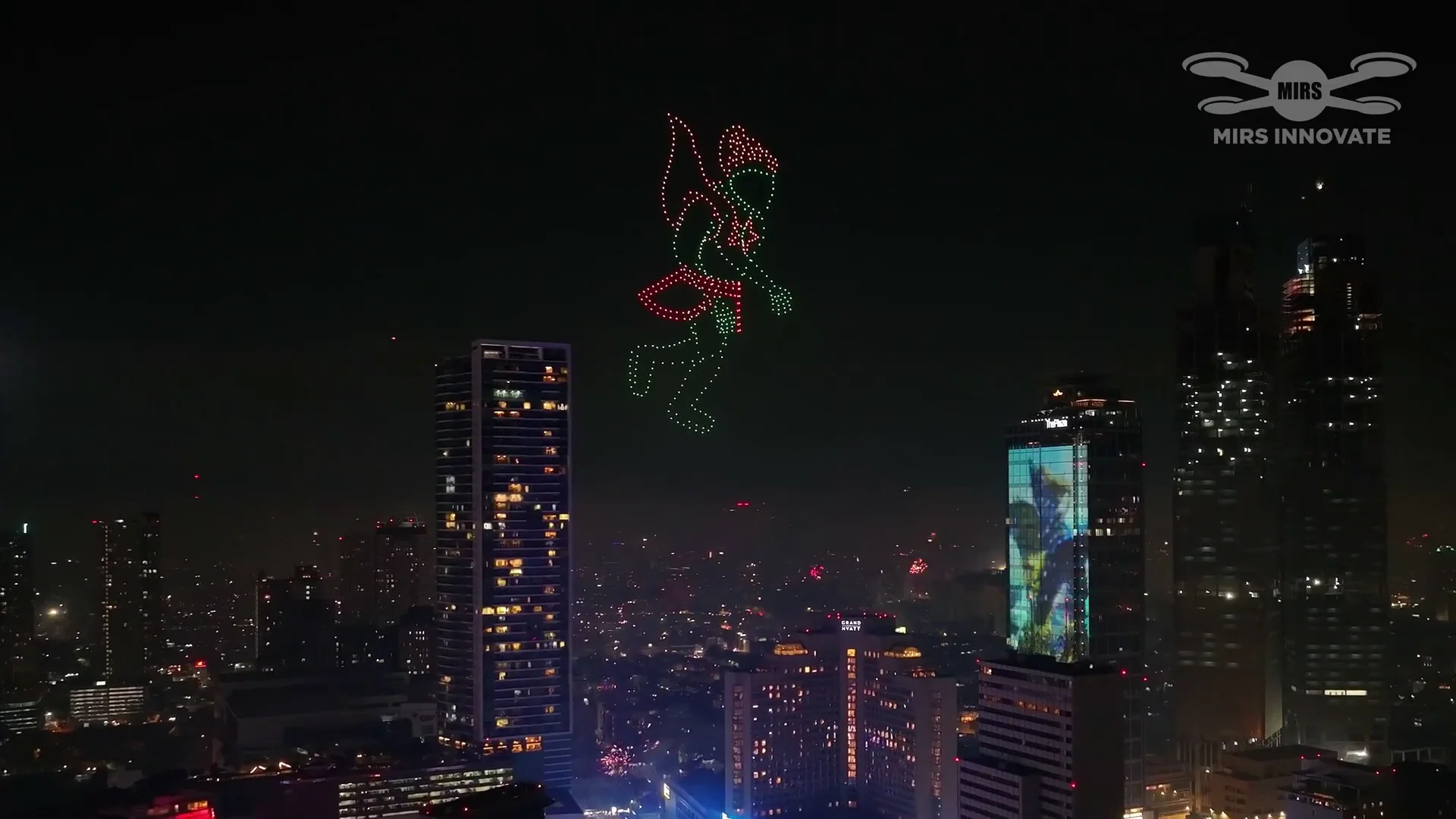 Colorful character formation above the Jakarta skyline at the Bundaran HI New Year's Eve drone light show in Indonesia