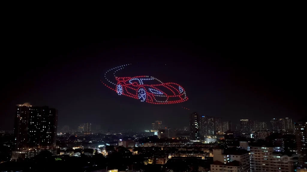 Sports car and racetrack drone formation above a Kuala Lumpur skyline