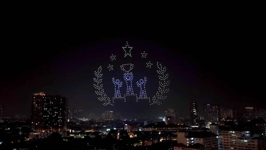 Trophy and laurel drone formation above an outdoor award-night audience in Kuala Lumpur