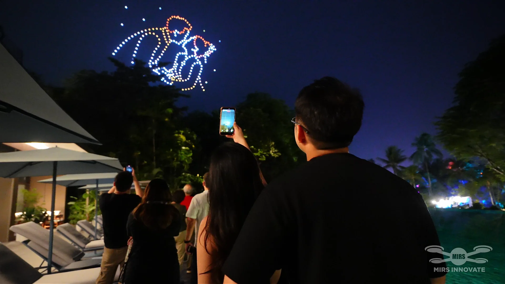 Guests recording The Day We Became Us during a private family drone show at Sentosa