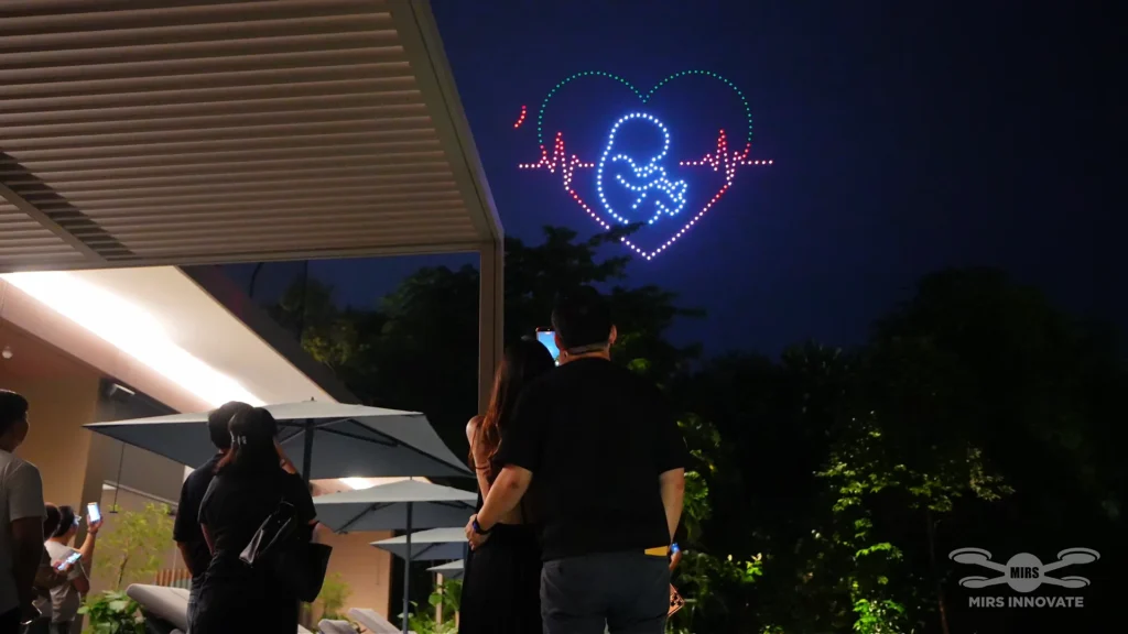 Guests watching A Little Heart, A Big Miracle during a private 300-drone family celebration at Palawan Sentosa Singapore
